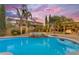 Sparkling pool with a built-in spa, surrounded by lush landscaping and cozy outdoor seating at 21575 E Twin Acres Ct, Queen Creek, AZ 85142