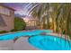 Private backyard oasis featuring a shimmering pool, spa, and serene lounge area amidst palm trees at 21575 E Twin Acres Ct, Queen Creek, AZ 85142
