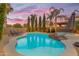 Inviting backyard pool with rock features, surrounded by lush greenery and lounge chairs for relaxation at 21575 E Twin Acres Ct, Queen Creek, AZ 85142