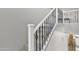 Staircase with carpeted steps, a decorative wrought iron railing, and white banister at 21575 E Twin Acres Ct, Queen Creek, AZ 85142
