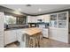 Well-lit kitchen boasts white cabinetry, an island with stools, and sleek countertops, ideal for culinary enthusiasts at 22039 N 86Th Ave, Peoria, AZ 85383