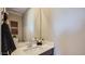 Powder room featuring a modern faucet, decorative items, and large mirror at 24643 N 164Th Dr, Surprise, AZ 85387