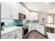 Well-lit kitchen with stainless steel appliances, white cabinetry, and attractive teal backsplash at 2511 W Queen Creek Rd # 258, Chandler, AZ 85248