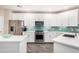 Kitchen featuring stainless steel appliances, teal backsplash, white cabinets, and stone countertops at 2511 W Queen Creek Rd # 258, Chandler, AZ 85248