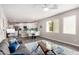 Bright living room with a sleek gray couch, large windows, and view into the modern kitchen at 2511 W Queen Creek Rd # 258, Chandler, AZ 85248