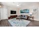 Living room with ceiling fan, television, artwork, and blue rug at 2511 W Queen Creek Rd # 258, Chandler, AZ 85248