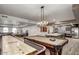 Spacious recreation room with a pool table, shuffleboard, and an adjacent modern kitchen at 2511 W Queen Creek Rd # 258, Chandler, AZ 85248