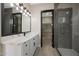 Bathroom boasts double sinks, modern vanity and a glass-enclosed shower with tile surround at 25846 W Denver Hill Dr, Wittmann, AZ 85361
