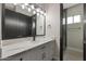 Bathroom with a marble countertop vanity, black hardware, and a glass door shower with a tile surround at 25846 W Denver Hill Dr, Wittmann, AZ 85361