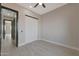 Bright bedroom with light-colored walls, modern barn door, and wood-look tile flooring at 25846 W Denver Hill Dr, Wittmann, AZ 85361