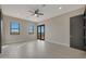 Bright bedroom with wood-look tile flooring, windows, and access to the backyard at 25846 W Denver Hill Dr, Wittmann, AZ 85361