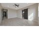 Bright bedroom with wood-look tile flooring, barn door to bathroom, and a ceiling fan at 25846 W Denver Hill Dr, Wittmann, AZ 85361