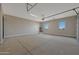 Empty garage with water heater and two windows at 25846 W Denver Hill Dr, Wittmann, AZ 85361
