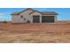 Side view of a house featuring two dark grey garage doors and a matching dark grey trimmed roofline at 25846 W Denver Hill Dr, Wittmann, AZ 85361