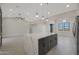 Bright, open-concept kitchen with white cabinets, stainless appliances, and a gray island with quartz countertops at 25846 W Denver Hill Dr, Wittmann, AZ 85361