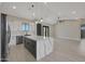 Bright, open-concept kitchen with white cabinets, stainless appliances, and a gray island with quartz countertops at 25846 W Denver Hill Dr, Wittmann, AZ 85361