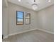 A bright living room with neutral walls, tile floors, and two windows providing natural light at 25846 W Denver Hill Dr, Wittmann, AZ 85361