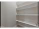 Walk-in pantry with white walls and four rows of shelving at 25846 W Denver Hill Dr, Wittmann, AZ 85361