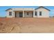 Rear view of the house showcasing a covered patio with a ceiling fan and clean architectural lines at 25846 W Denver Hill Dr, Wittmann, AZ 85361