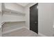 Walk-in closet features sleek tile flooring and built-in shelving at 25846 W Denver Hill Dr, Wittmann, AZ 85361