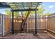 Cozy backyard featuring a wooden trellis, fenced perimeter, and quaint tree at 286 W Palomino Dr # 147, Chandler, AZ 85225