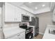 Updated kitchen with stainless steel appliances, white cabinets, and quartz countertops at 286 W Palomino Dr # 147, Chandler, AZ 85225