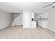 Open-concept living room features wood floors and seamlessly integrates the kitchen with white cabinets at 286 W Palomino Dr # 147, Chandler, AZ 85225