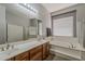 Bathroom with a large mirror, double sinks, soaking tub, shower, and linen closet at 2976 E Clifton Ave, Gilbert, AZ 85295