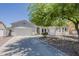 Charming single-story home featuring a three-car garage and low-maintenance desert landscaping under a sprawling, mature tree at 2976 E Clifton Ave, Gilbert, AZ 85295