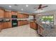 Spacious kitchen with granite countertops, wood cabinets, tile flooring, island, and stainless steel appliances at 3018 E Vernon St, Gilbert, AZ 85298