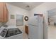 Functional laundry room with washer, dryer, sink, storage cabinets, and a refrigerator at 3018 E Vernon St, Gilbert, AZ 85298