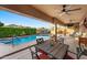 Relaxing covered patio with dining and seating areas, overlooking a sparkling pool and lush greenery at 3018 E Vernon St, Gilbert, AZ 85298