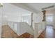 Loft with hardwood floors, decorative railing, and stone accents looking down into the living room at 31259 N 42Nd Pl, Cave Creek, AZ 85331