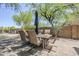 Outdoor dining set on a paver patio, shaded by a large tree and umbrella at 31259 N 42Nd Pl, Cave Creek, AZ 85331