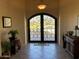 Grand foyer featuring a decorative wrought iron front door and neutral tile flooring at 35401 N Via Tramonto St, Phoenix, AZ 85086