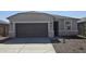Charming single-story home featuring neutral stucco, a large garage, stone accents, and low maintenance landscaping at 35512 N Common Ct, San Tan Valley, AZ 85140