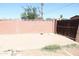 A fenced backyard featuring a concrete patio and a view of the surrounding landscape under a clear blue sky at 3651 W Mariposa St, Phoenix, AZ 85019