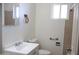A well-lit bathroom with a white sink and toilet with beige tiles on the wall at 3651 W Mariposa St, Phoenix, AZ 85019