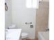 A well-lit bathroom featuring a sink, toilet, bathtub and beige tile on the walls at 3651 W Mariposa St, Phoenix, AZ 85019