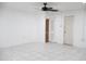 A white bedroom featuring tiled flooring, a ceiling fan, and a closet with a louvered door at 3651 W Mariposa St, Phoenix, AZ 85019