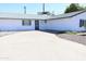 A well-maintained single-story home with a gray roof, a garage, and a long driveway at 3651 W Mariposa St, Phoenix, AZ 85019