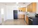 Functional kitchen featuring wood cabinets, black appliances, and neutral tile flooring at 3651 W Mariposa St, Phoenix, AZ 85019