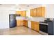 Bright kitchen with wood cabinets, a ceiling fan, and modern black and stainless steel appliances at 3651 W Mariposa St, Phoenix, AZ 85019