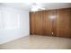 Spacious living room with tile flooring, a ceiling fan, and wood paneled accent wall at 3651 W Mariposa St, Phoenix, AZ 85019
