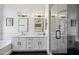 Modern bathroom with double sink vanity, glass-enclosed shower, and designer lighting fixtures at 4440 E Tether Trl, Phoenix, AZ 85050