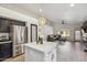 Bright kitchen featuring stainless steel appliances, black cabinets, a white island, and an open concept to living room at 4440 E Tether Trl, Phoenix, AZ 85050