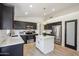 Well-lit kitchen featuring black cabinets, stainless steel appliances, an island, and light countertops at 4440 E Tether Trl, Phoenix, AZ 85050