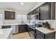 Modern kitchen featuring stainless steel appliances, black cabinets, a white island, and modern fixtures at 4440 E Tether Trl, Phoenix, AZ 85050