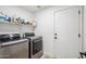 Convenient laundry room with modern washer and dryer, built-in shelving, and ample storage space at 4440 E Tether Trl, Phoenix, AZ 85050