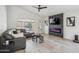 Bright living room featuring a vaulted ceiling, fireplace, gray sofa, and light wood floors at 4440 E Tether Trl, Phoenix, AZ 85050